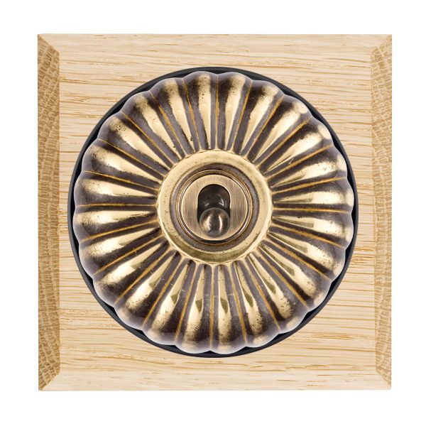 Bloomsbury Chamfered Light Oak 1 gang 20AX 2 Way Toggle Antique Brass Fluted Dome/Black Collar