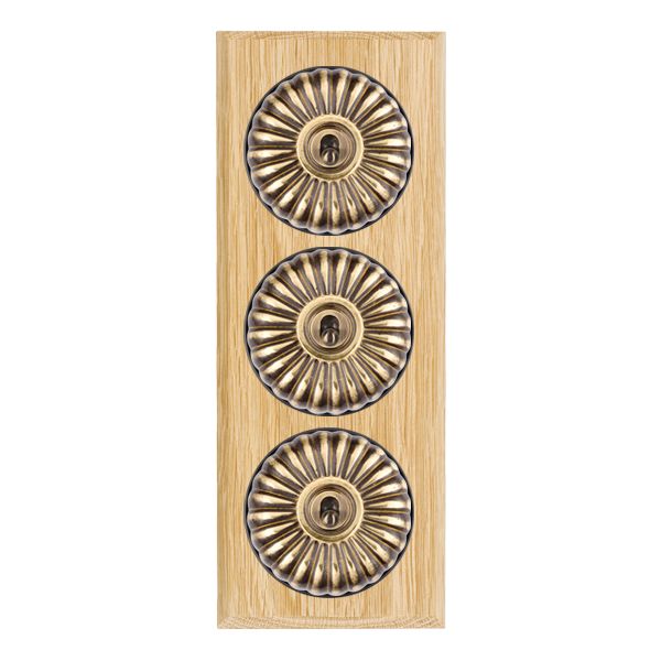 Bloomsbury Chamfered Light Oak 3 gang 20AX 2 Way Toggle Antique Brass Fluted Dome/Black Collar