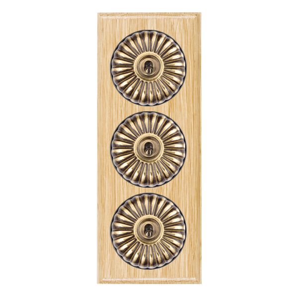 Bloomsbury Ovolo Light Oak 3 gang 20AX 2 Way Toggle Antique Brass Fluted Dome/Black Collar