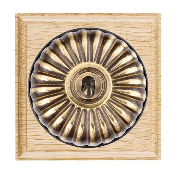 Bloomsbury Ovolo Light Oak 1 gang 20AX Intermediate Toggle Antique Brass Fluted Dome/Black Collar