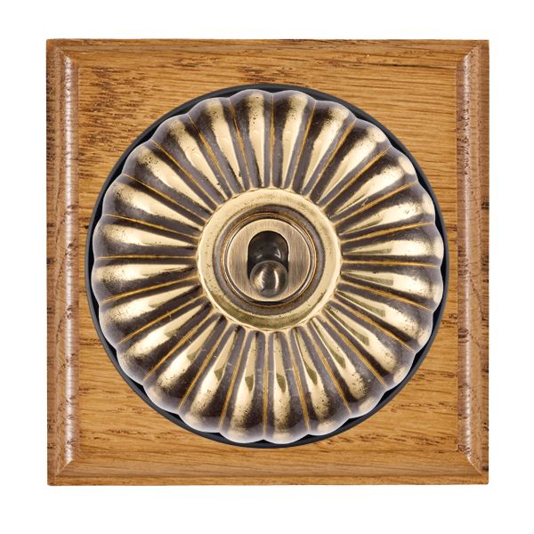 Bloomsbury Ovolo Medium Oak 1 gang 20AX Double Pole Toggle Antique Brass Fluted Dome/Black Collar